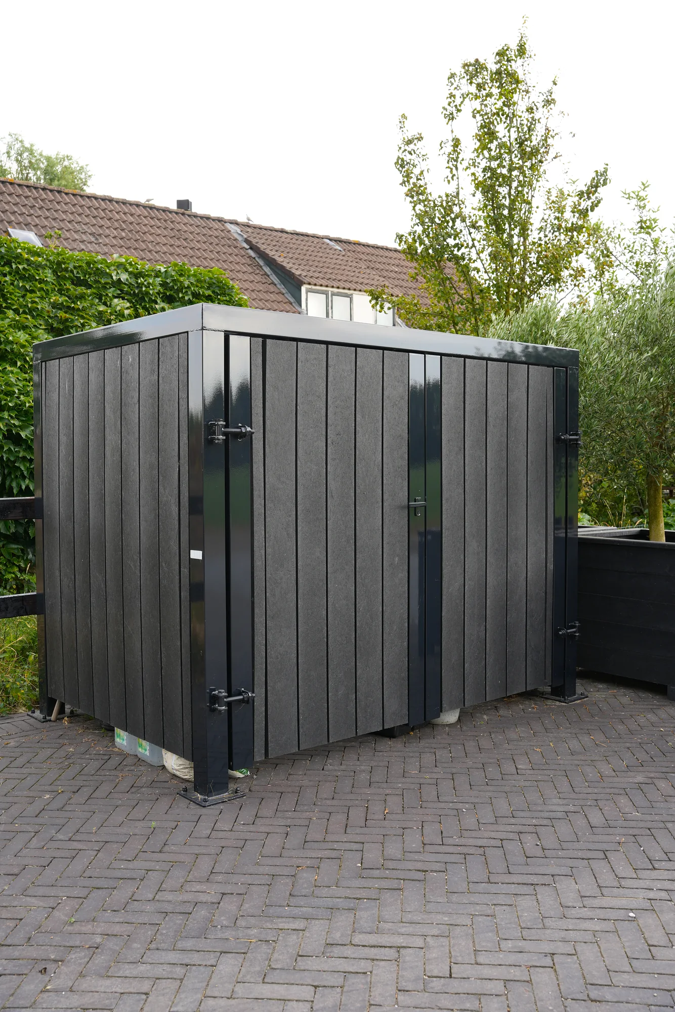 Donkere maatwerk tuinberging met stalen frame