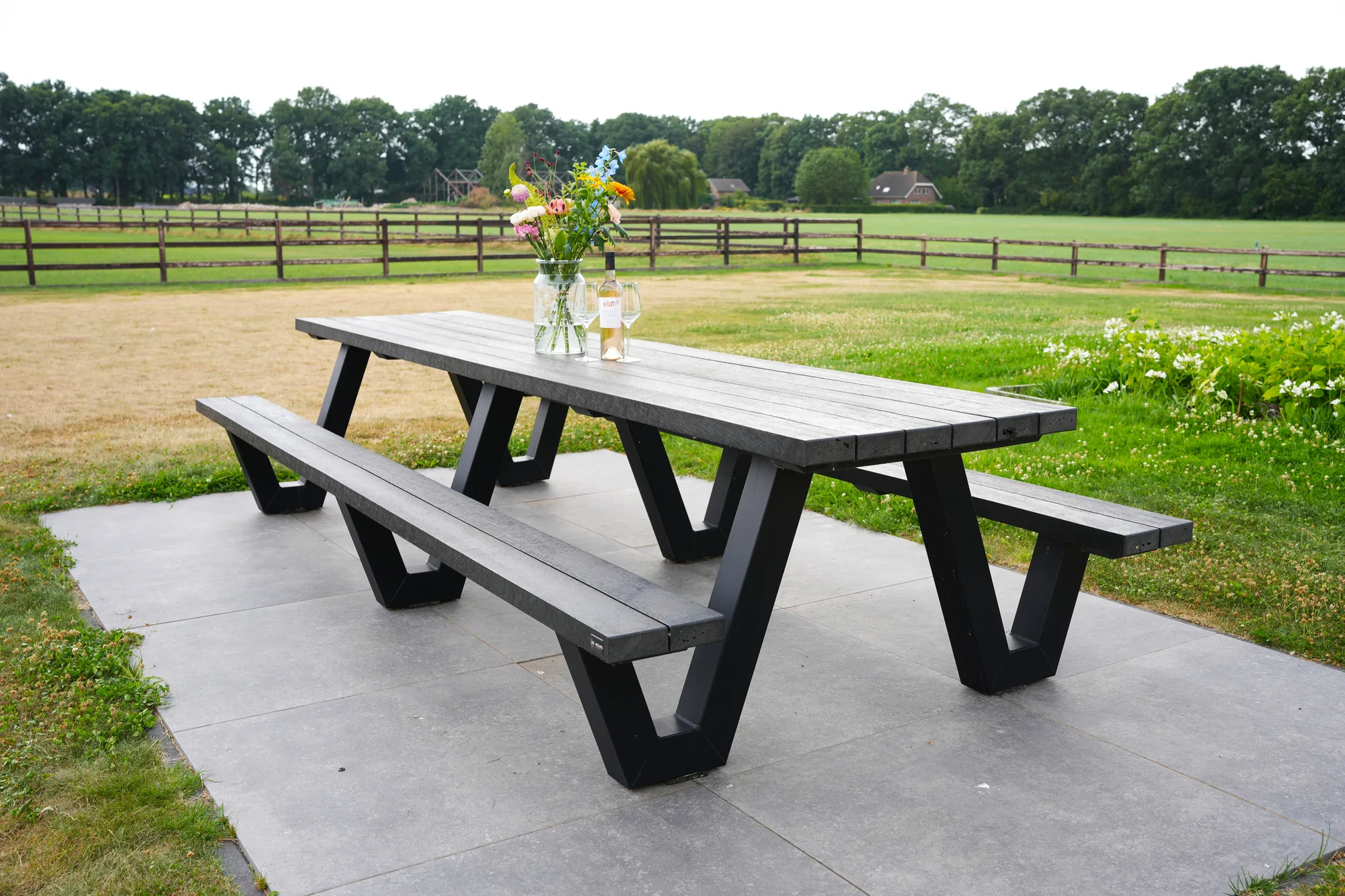 Grote picknicktafel met kunststof tafelblad en banken op een zwart stalen onderstel