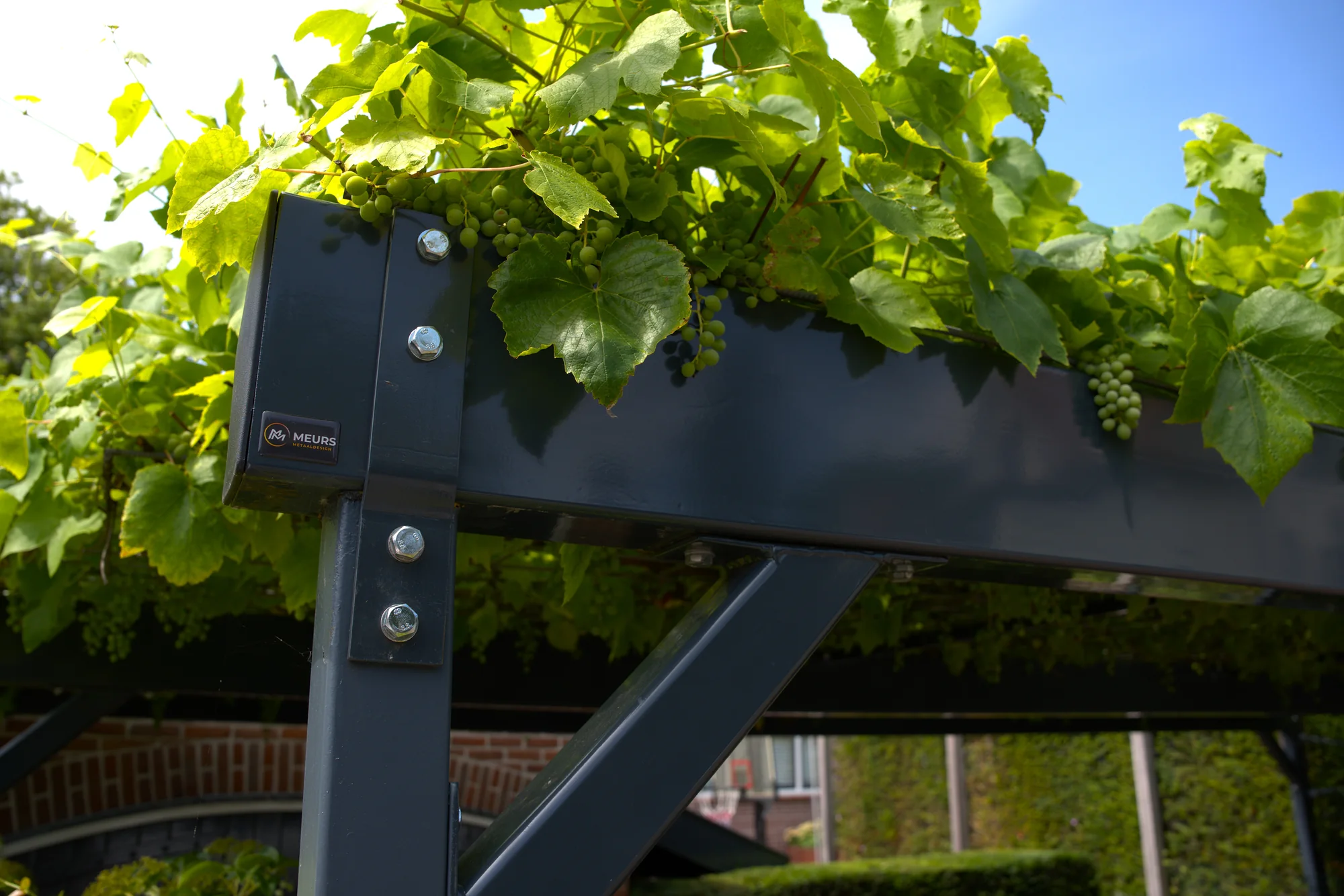 Detail van de gepoedercoate stalen pergola met bevestiging en Meurs Metaaldesign merkteken