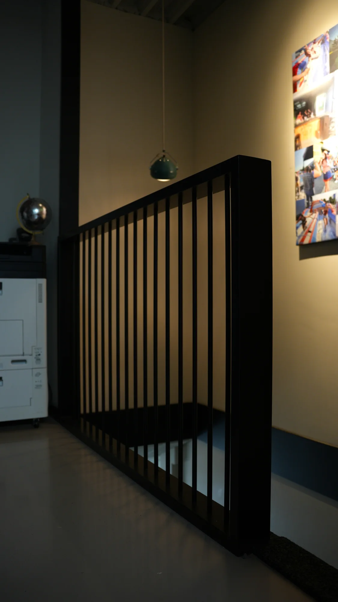 Zwarte stalen roomdivider met verticale spijlen in een woning